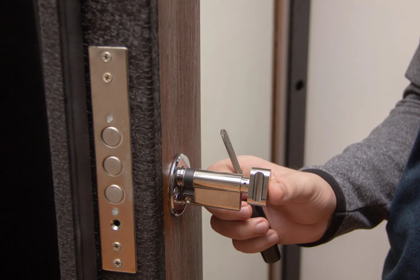 Serrurier intervenant sur une serrure de porte d'entrée près du carrefour de l'Odéon, Paris 6e (75006)